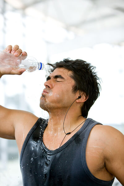 Strong gym man splashing water on his face